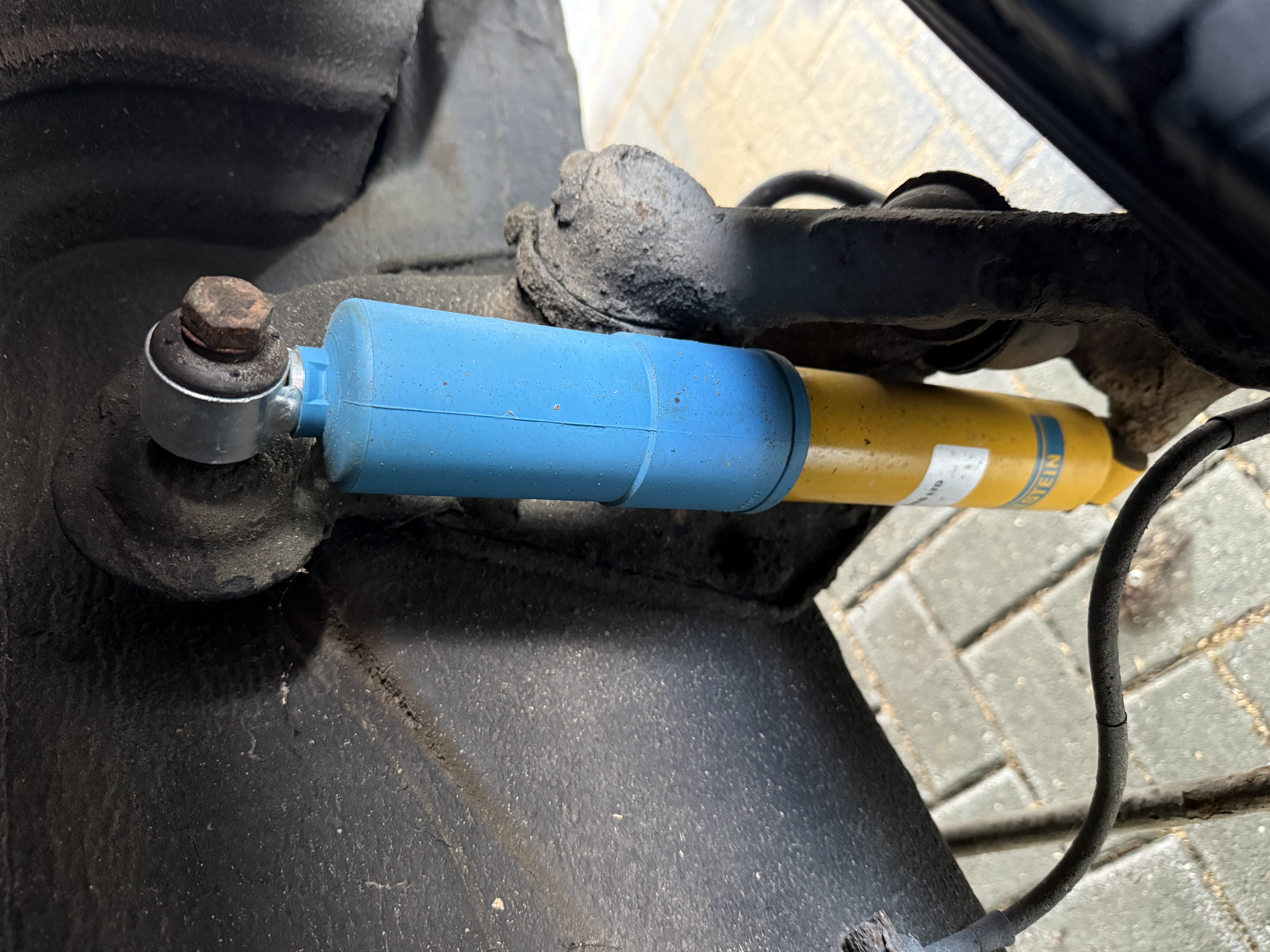Side-by-side comparison of old worn-out shock absorber versus new Bilstein B6 showing difference in condition