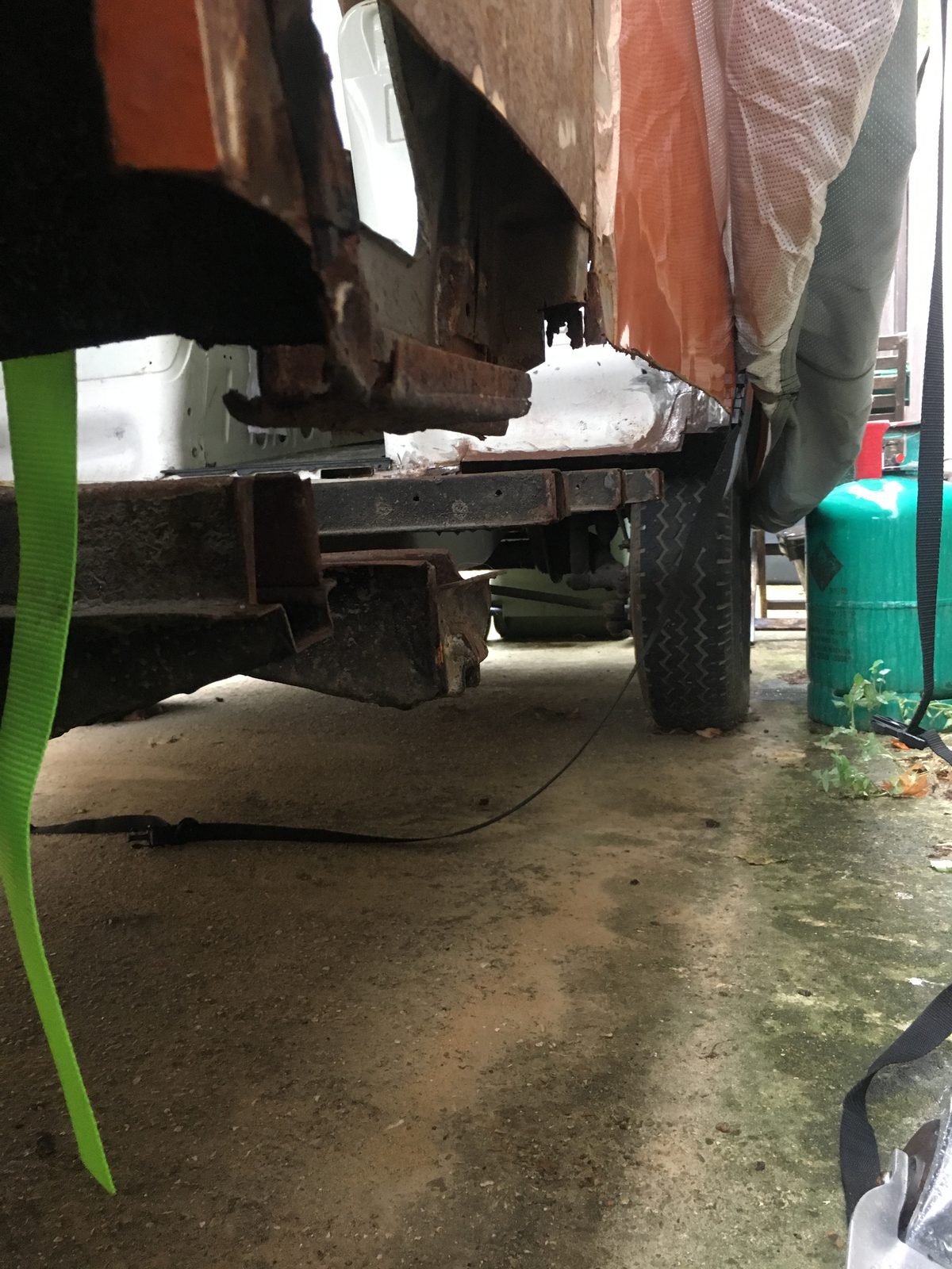 Jenny's rust damage underneath — severe sill and chassis rust visible from below