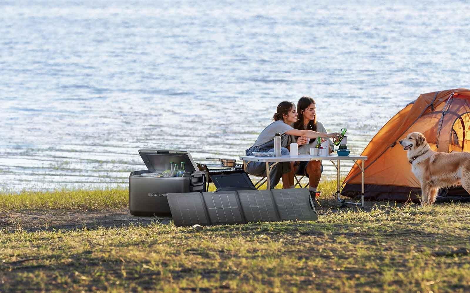 Camping scene with EcoFlow fridge, solar panel, and happy campers by the lake